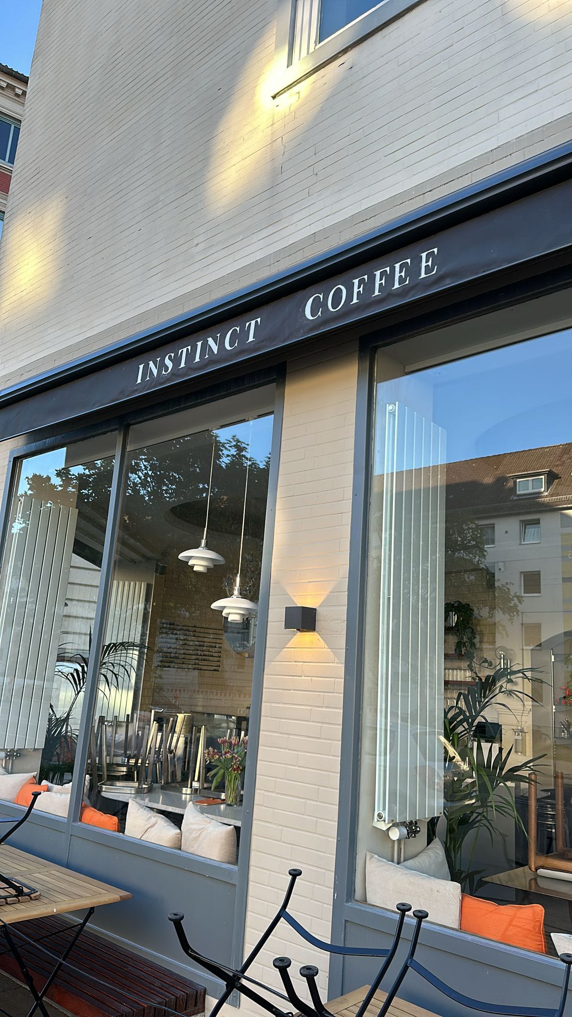 Schwarze Vollkassettenmarkise mit Volantbeschriftung bei Instinct Coffee in Hamburg bei Tag
