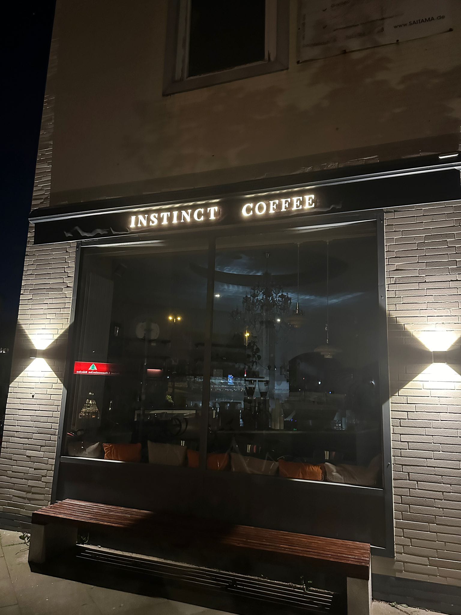Detail der beleuchteten Beschriftung INSTINCT COFFEE am schwarzen Markisenvolant