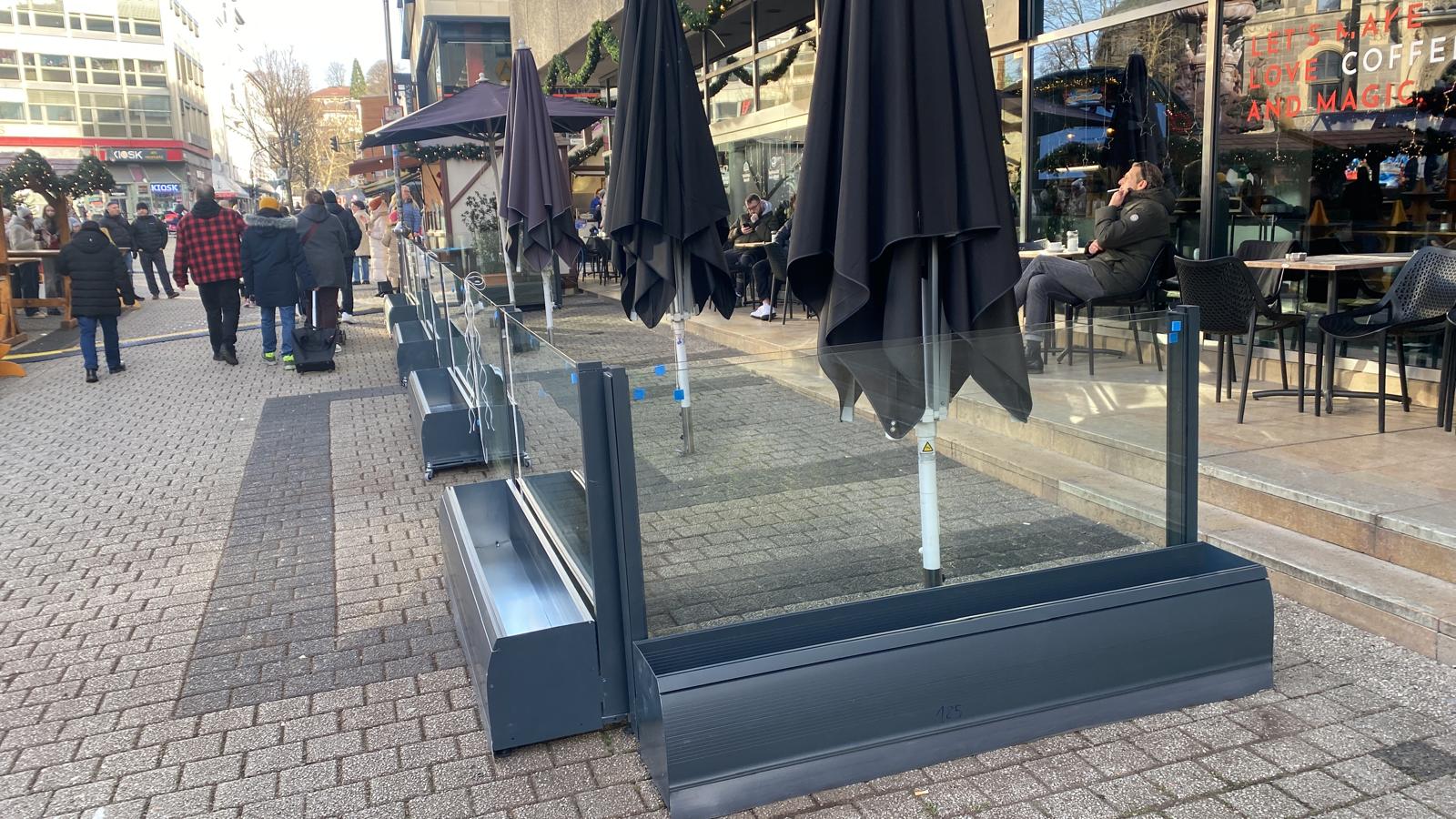 Glas-Windschutz mit Pflanzkästen vor einem Café am Neumarkt in Wuppertal