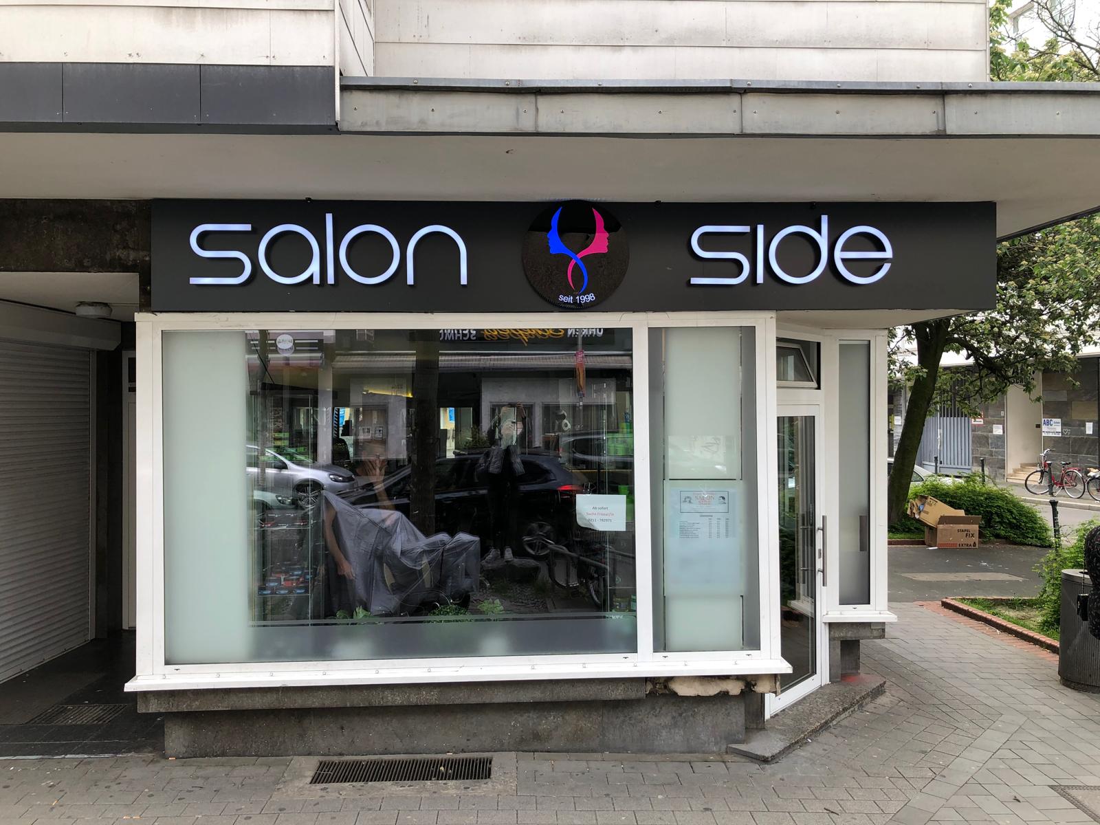 Salon Side, Düsseldorf Kölner Straße: Beleuchtet – Frontansicht der Werbeanlage von Salon Side an der Kölner Straße in Düsseldorf.